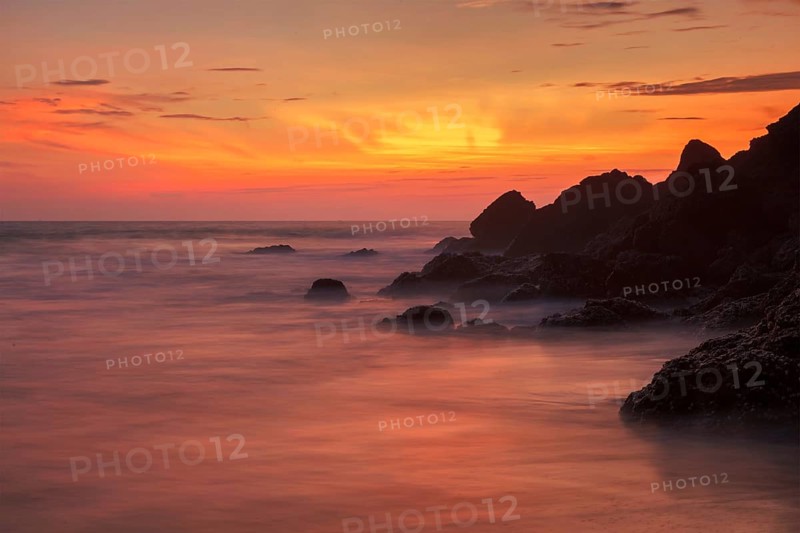Sunset on Varkala beach popular tourist destination in Kerala state, South India. Long exposure water blur
