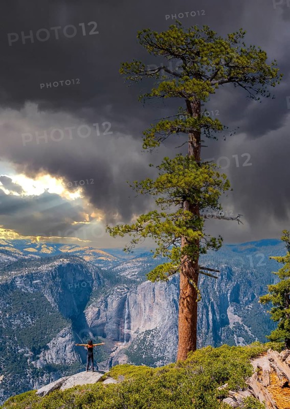 A young woman in Sentinel Dome looking at Upper Yosemite Fall, Yosemite National Park. United States
