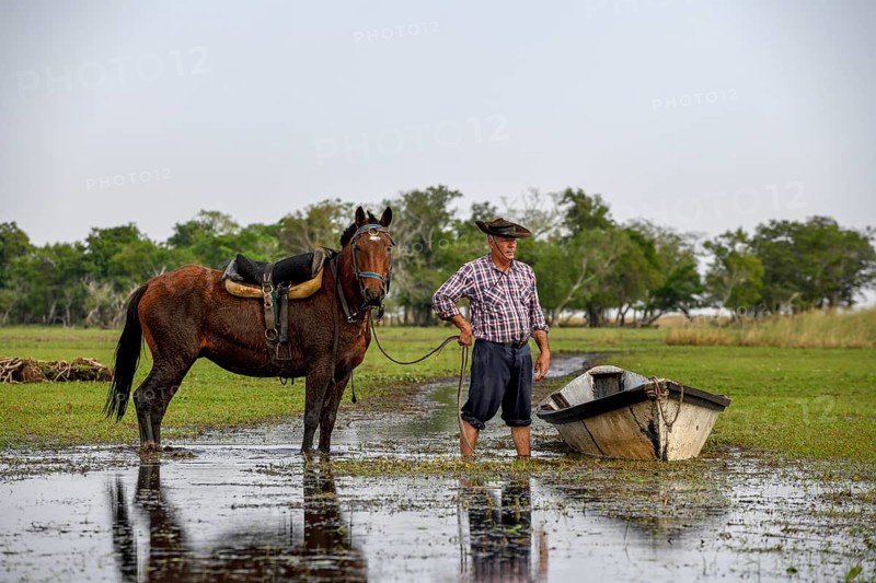 Gaucho with horse and boat at Puesto Mingo, Esteros del Iberá, near Concepción del Yaguareté Corá, Corrientes Province, Argentina, South America