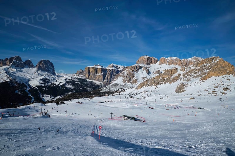 View of a ski resort piste with people skiing in Dolomites in Italy. Ski area Belvedere. Canazei, Italy, Europe