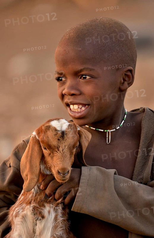 Himba boy with a goat, Ombombo, Kaokoland, Kunene, Namibia, Africa