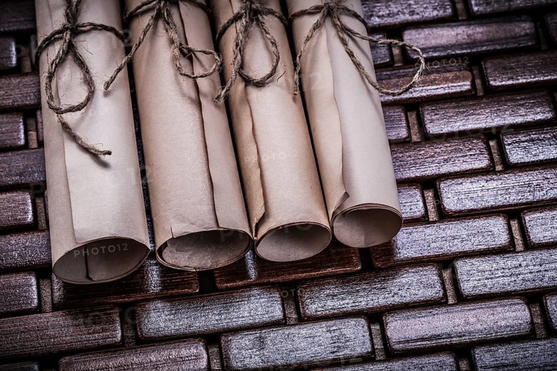 Pile of aged paper rolls on rowing wooden mat