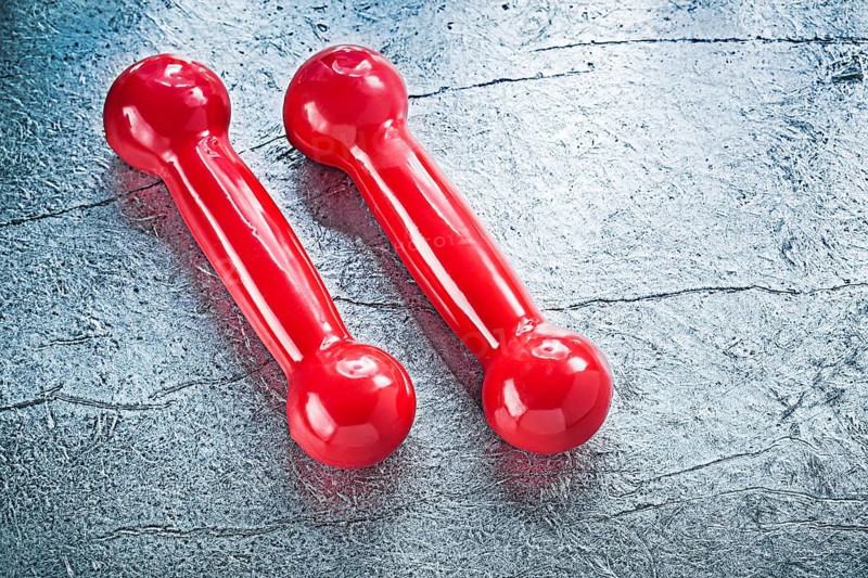 Pair of red dumbbells on silver surface fitness concept