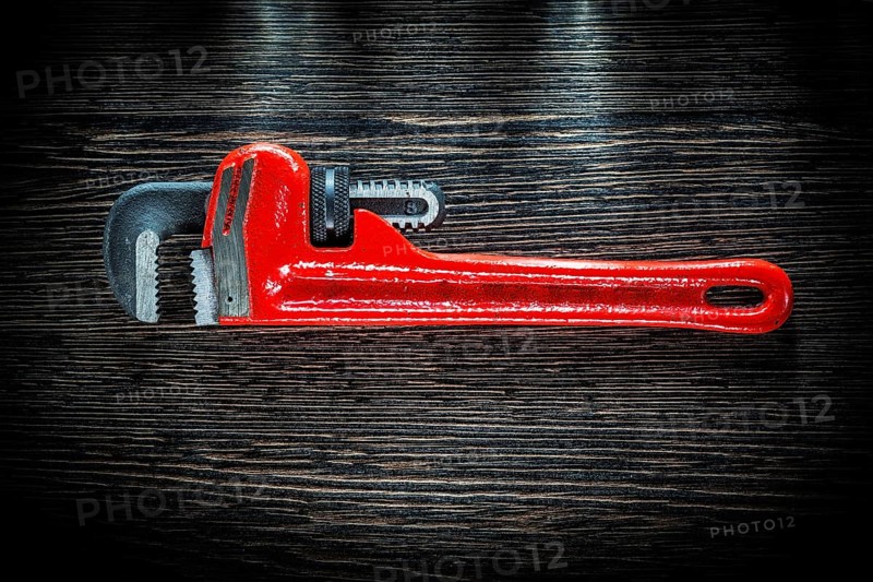 Pipe wrench on vintage wooden board