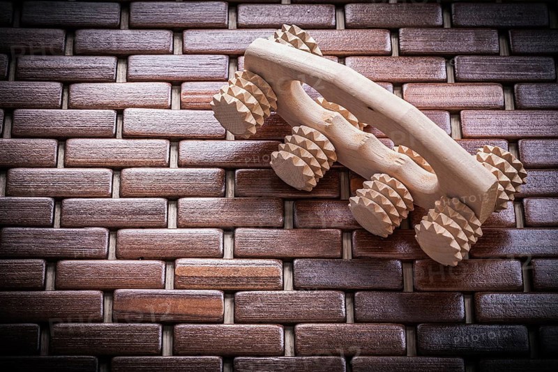 Wood massager on checked wooden matting healthcare concept