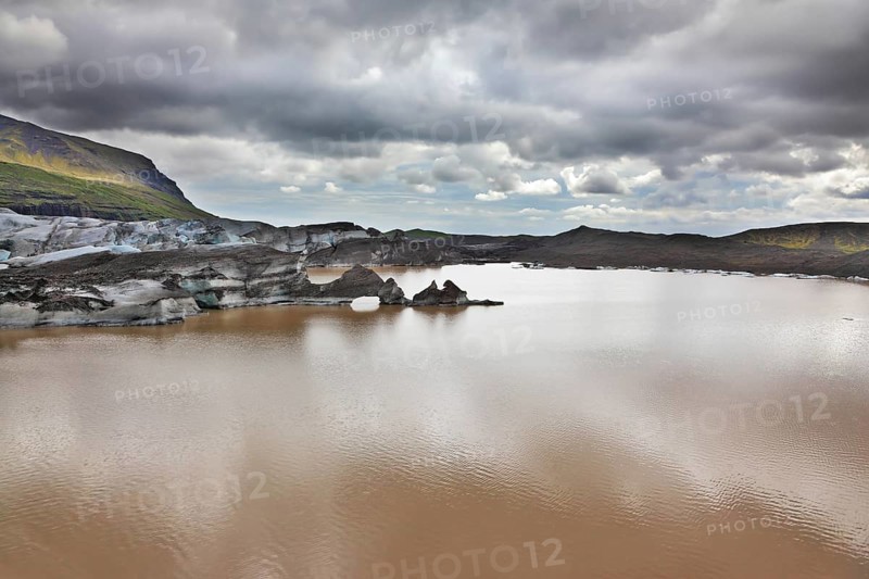 Skaftafell National Park. Ice covered with volcanic ash. Mirror Lake, formed as a result of thawing of a glacier Vatnajokull glacier spurs. Iceland in July