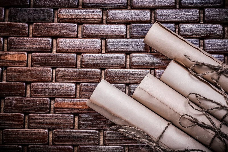 Rolled vintage documents on wicker wooden matting