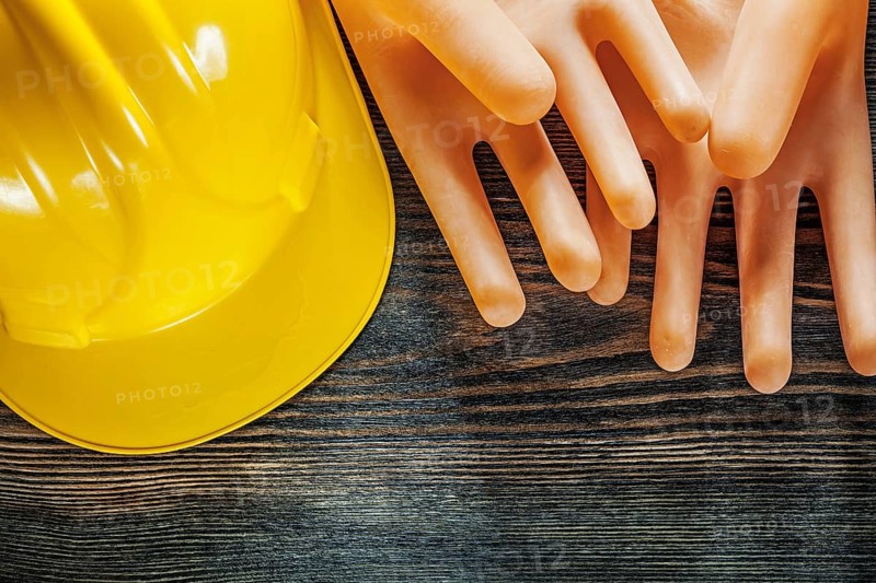 Hard hat insulating gloves on wooden board