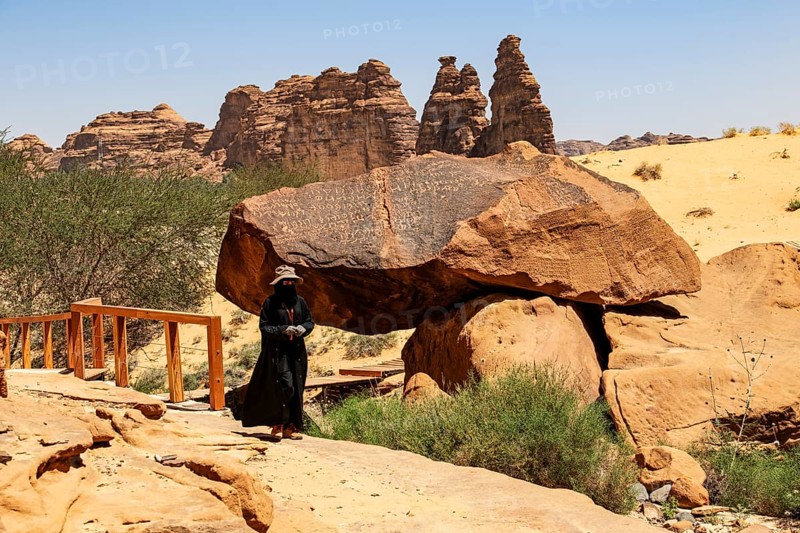Guide in Jebel or Jabal Ikmah shows large open library, rock bands with petroglyphs, rock carvings in open-air museum, Dadan, sandstone, Al Ula, Saudi Arabia, Asia
