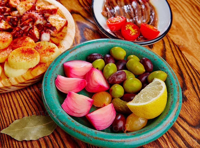 Olives and onion pickles tapas with anchovies and octopus gallega