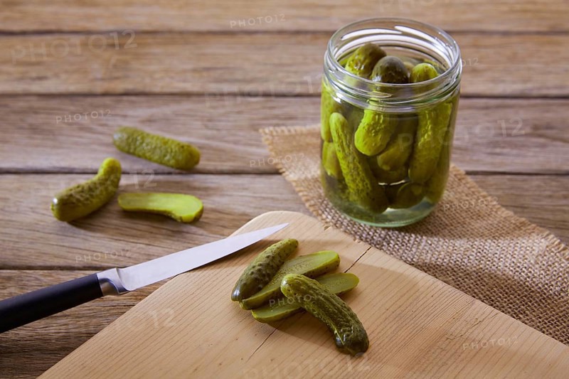 Bottled pickles cucumbers in vintage wooden table