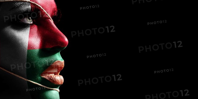 Madagascar flag painted on a face of a young woman, national flag on face
