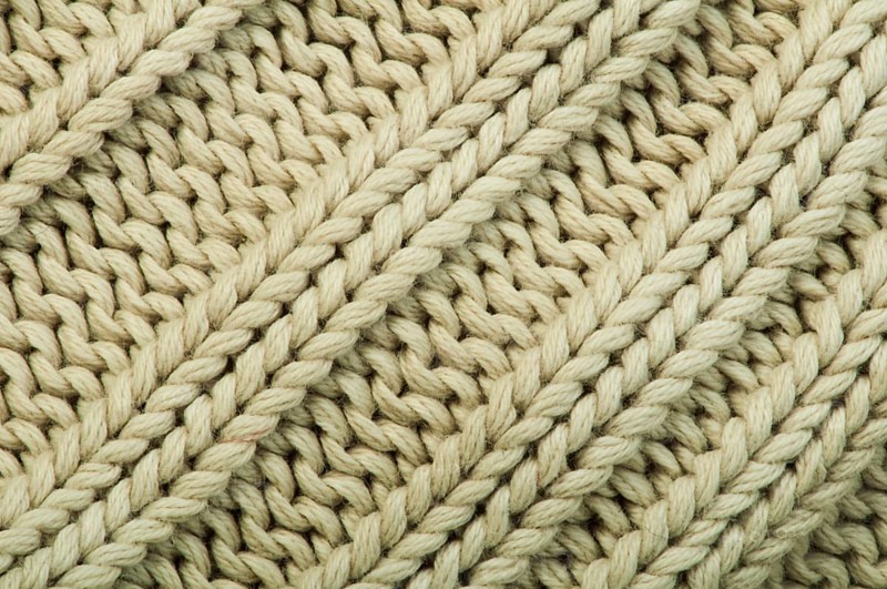 Old knit sweater background. Beige color. Studio shot