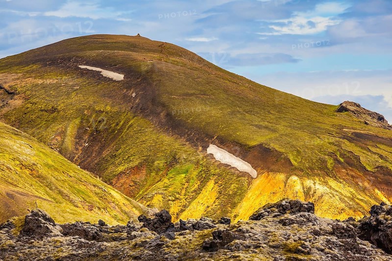 Incredible shades of rhyolitic mountains - yellow, orange, green and blue. Summer volcanic tundra. Travel to Iceland in July