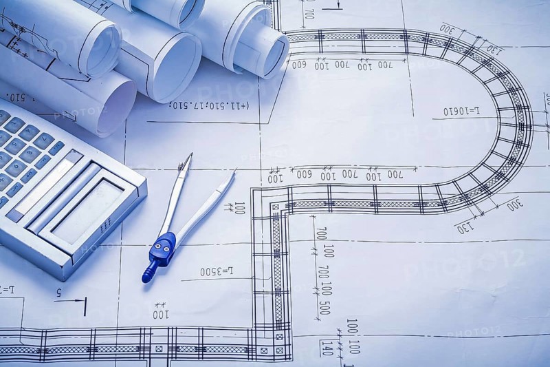 Stack of rolled blueprints calculator compass construction concept