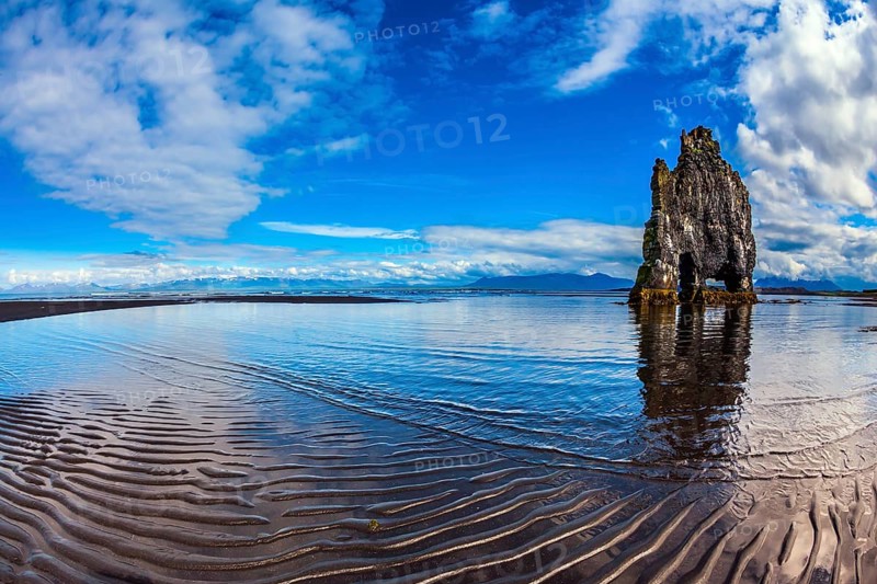 Rock Hvitserkur on the sea beach in the form of a huge elephant. Ocean tide at sunset. The north coast of Iceland. The concept of northern extreme tourism