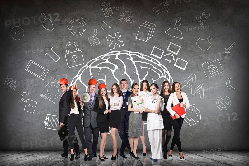 Woman stands beside big drawn brain on the gray wall
