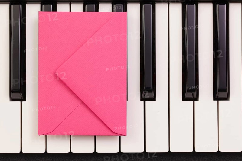 Funny arrangement envelope on the piano keybords - Flat lay image