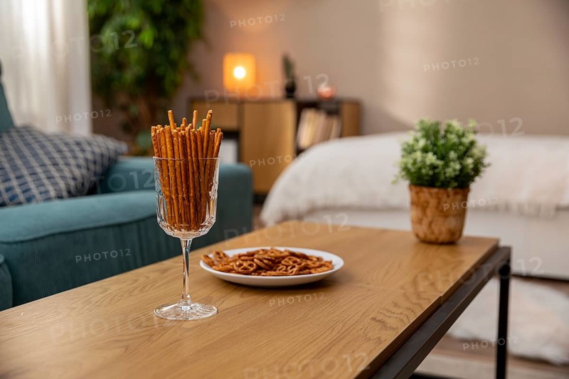 This is a stylish living space that includes pretzel snacks and indoor plants to create a cozy, inviting ambiance