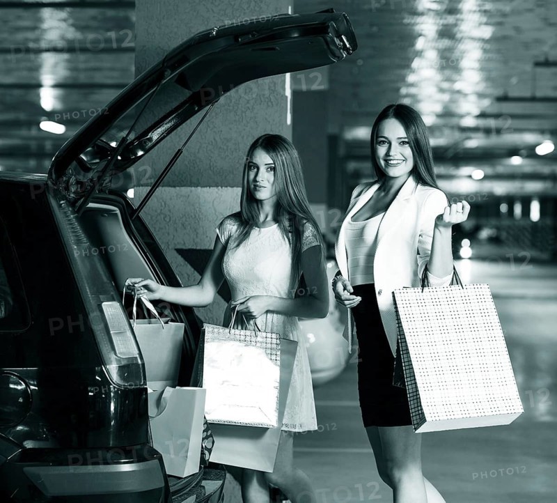 Two young shoppers on a car parking