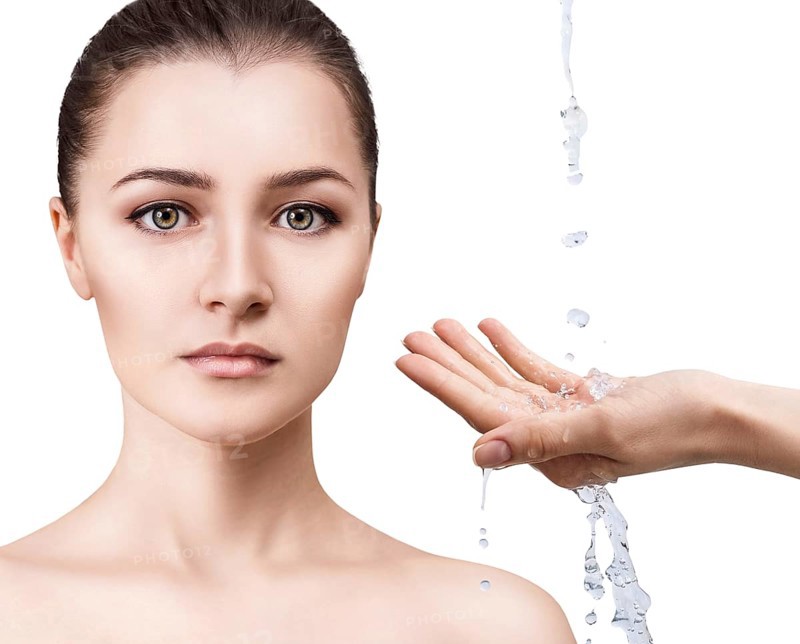 Beautiful woman face and splashes of water in hands. Cleansing and moisturizing concept