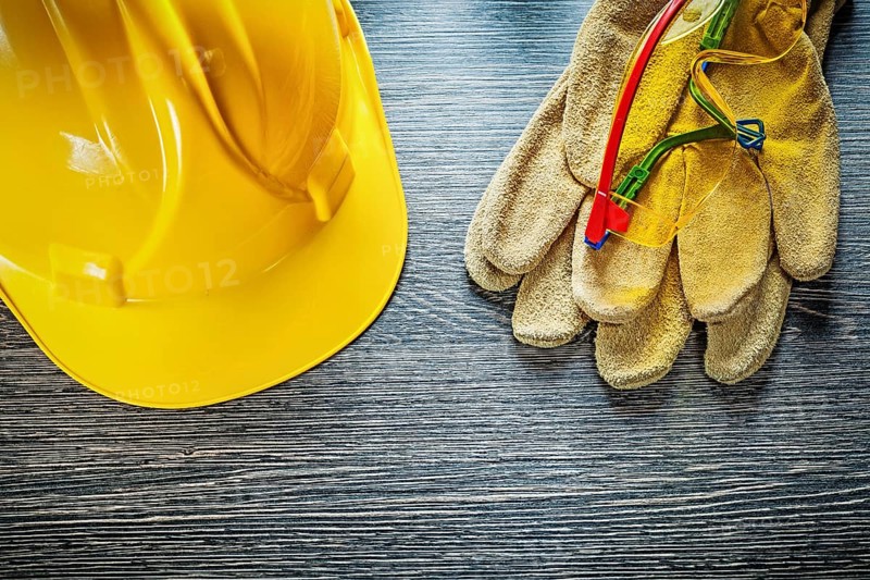 Safety gloves cap goggles on wooden board