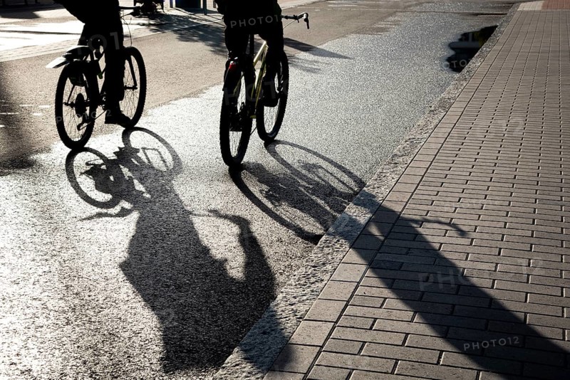 Silhouette of unrecognised people cycling outdoor in the morning. People exercising. Healthy lifestyle