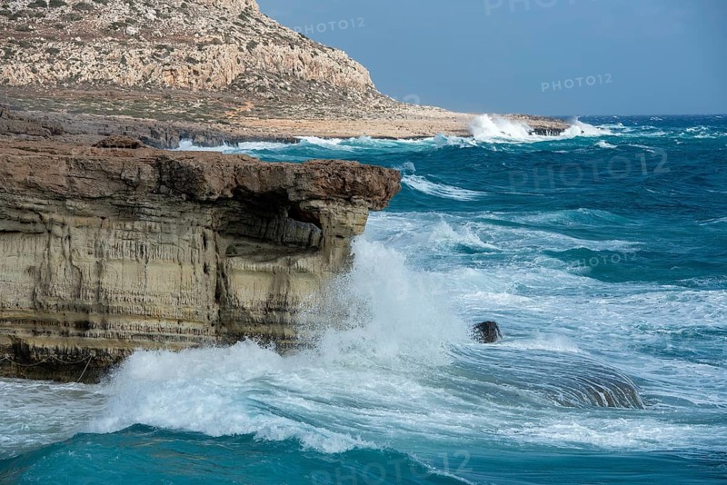 Waves crashing on rocky coast. Windy weather, Powerful sea waves braking on rocks