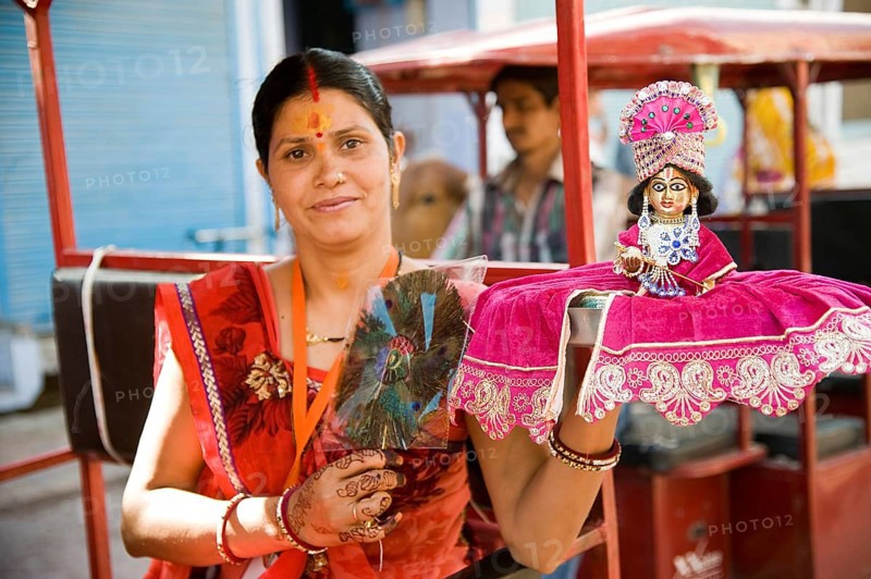 Woman holding krishna idol on hand, mathura, uttar pradesh, india, asia