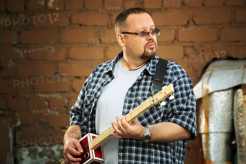 Man playing his three string cigar box guitar