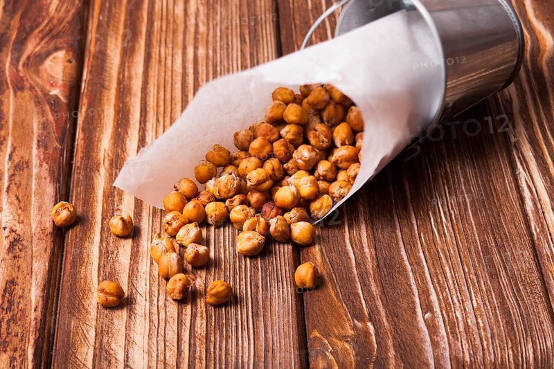 Spicy baked chickpeas in a metal pail on the wooden background