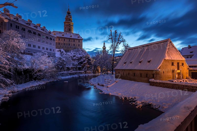 Winter view of Cesky Krumlov, picturesque houses under the castle with snow-covered roofs. Narrow streets and the Vltava river. Travel and Holiday in Europe. Christmas time. UNESCO World Heritage. Czech Republic