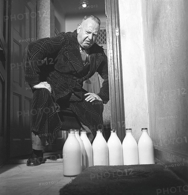Man of the 1940s. A man visibly disapointed over the several milk bottles standing on his doorstep. He has stayed behind in the city apartment while his wife and family has a summer vacation. Perhaps he has enjoyed beer more than milk these bachelor days. Sweden 1942 ref C22-4