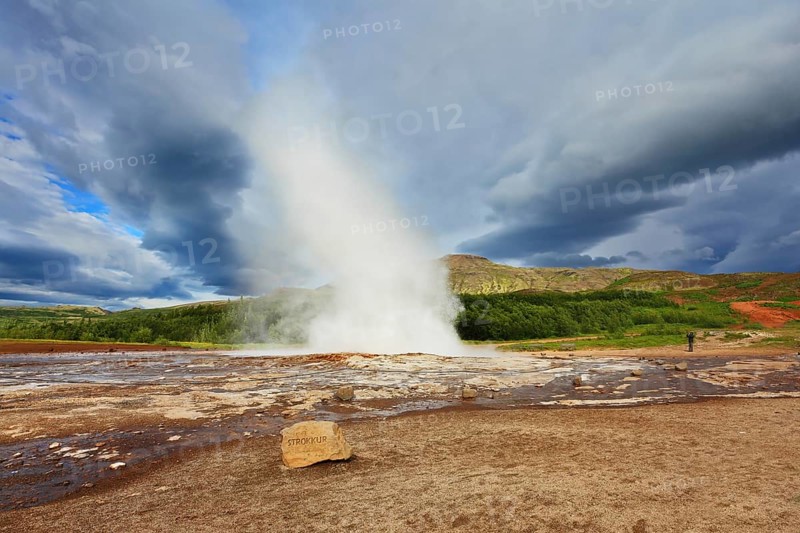 Iceland in the summer. Gushing geyser Strokkur. High column of hot water and steam from the crater of the geyser