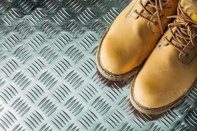 Waterproof safety boots on corrugated metal plate
