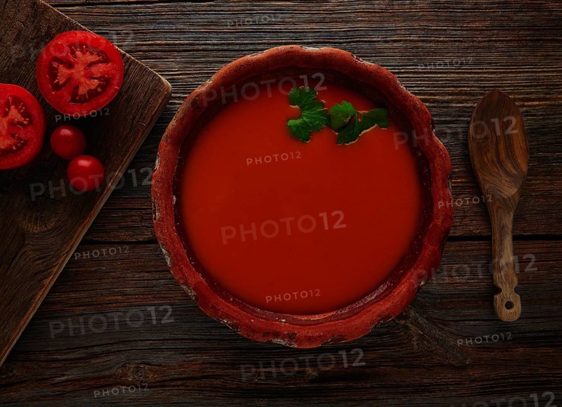 Tomato sauce on clay dish and dark wood background