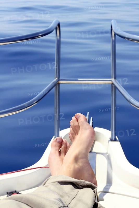 Boat bow man feet blue sea view sailing ocean relaxed calm saltwater
