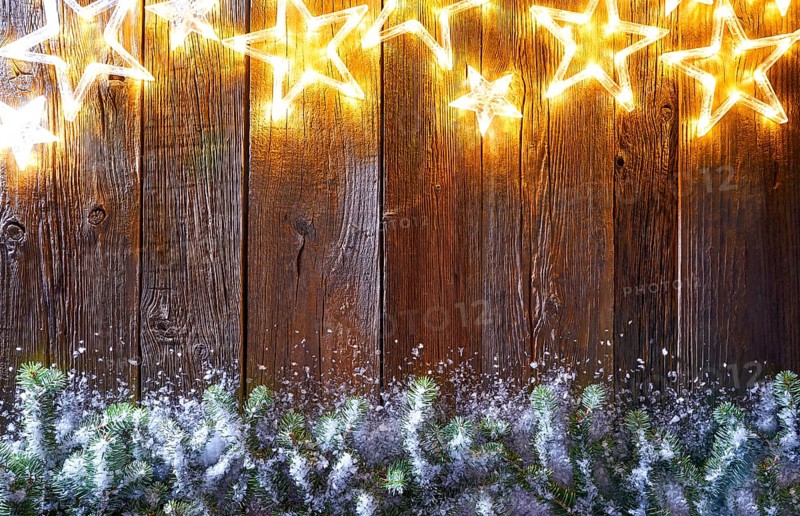 Christmas glowing stars and snow fir on vintage wooden background copy space