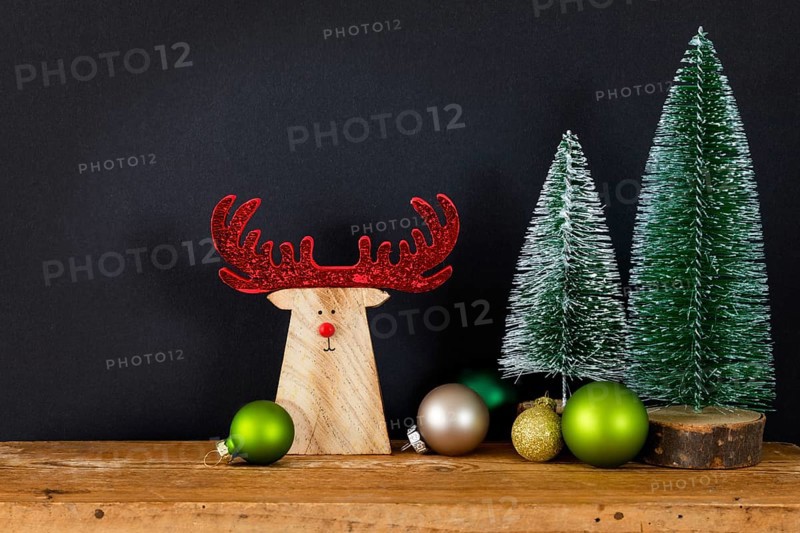 A Christmas decoration black background with tree glass balls and wooden reindeer