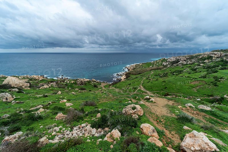 View over a green landscape with rocks and the Mediterranean sea in the background in Selmun, Malta, Europe