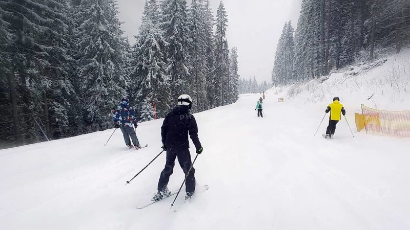 People skiing on the snowy slope of Bukovel ski resort in the Ukrainian Carpathian mountains
