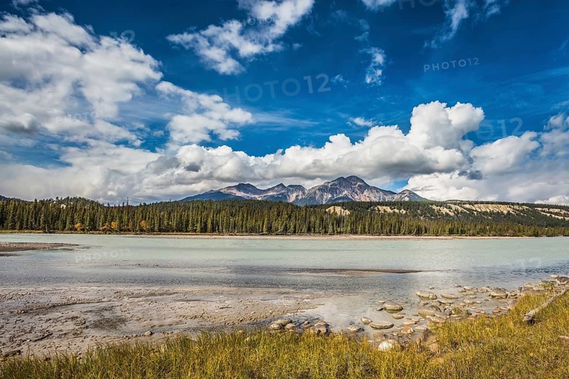 Beneaped Medicine Lake in the fall. Evergreen forests and snow-capped Rocky Mountains of Canada