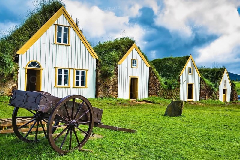 The village first settlers in Iceland. The reconstituted village - Pioneer Museum - Viking. Old wooden two-wheeled carriage on front lawn of the house