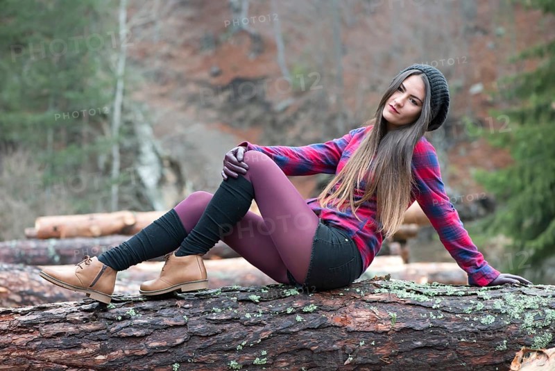 Young woman on wood logs