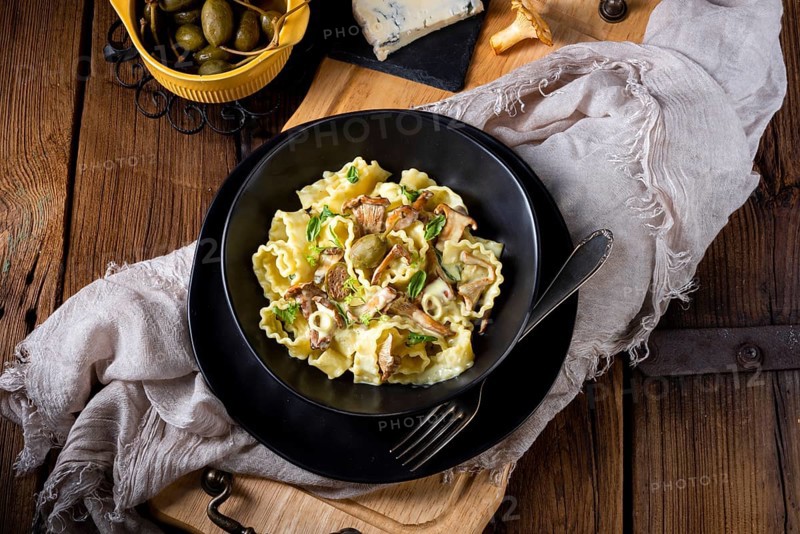 Reginette pasta in cream sauce with fresh chanterelles and capers