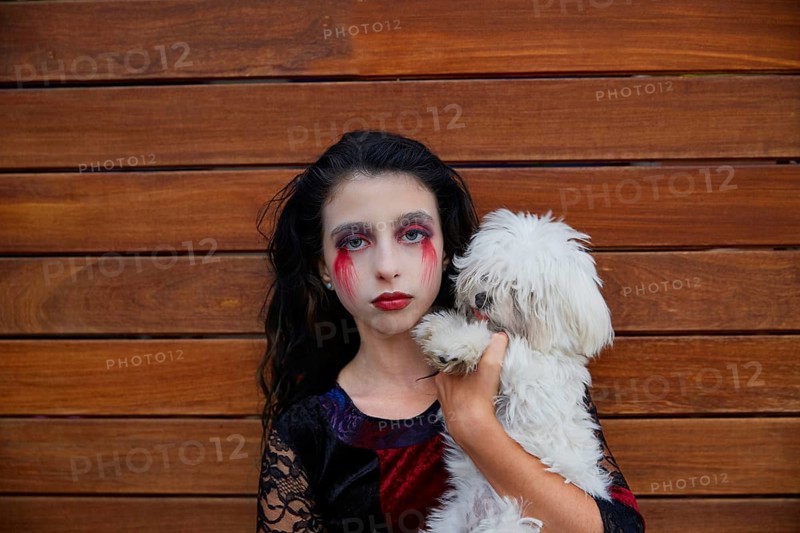 Halloween kid girl custome with bloody makeup on wooden wall