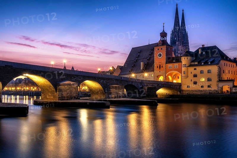 Stone Bridge and St Peter's Cathedral at dusk sunrise in Regensburg with danube