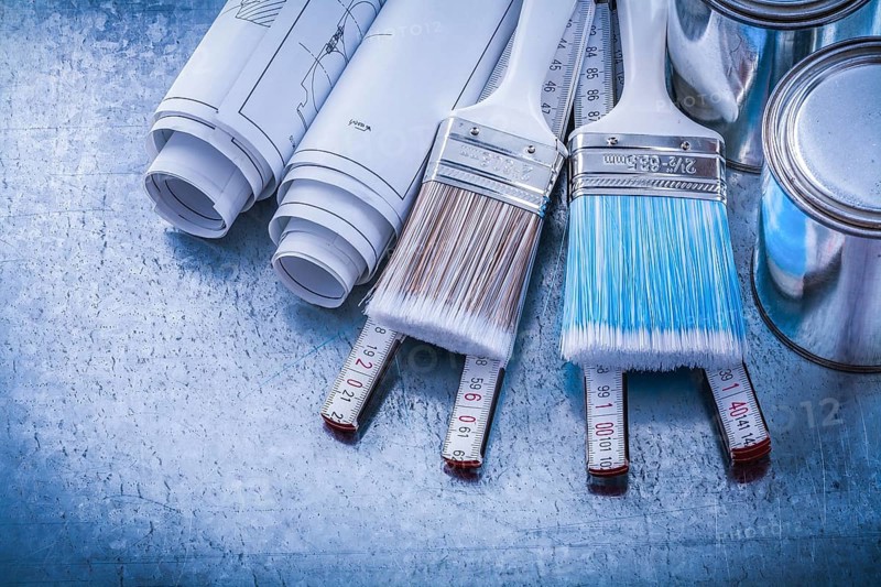 Top view of paint brushes cans construction drawings wooden meter
