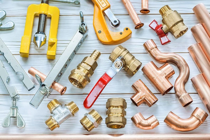 Plumbing tools copper pipes pipe cutter fittings valwes flaring clamps on white wooden boards