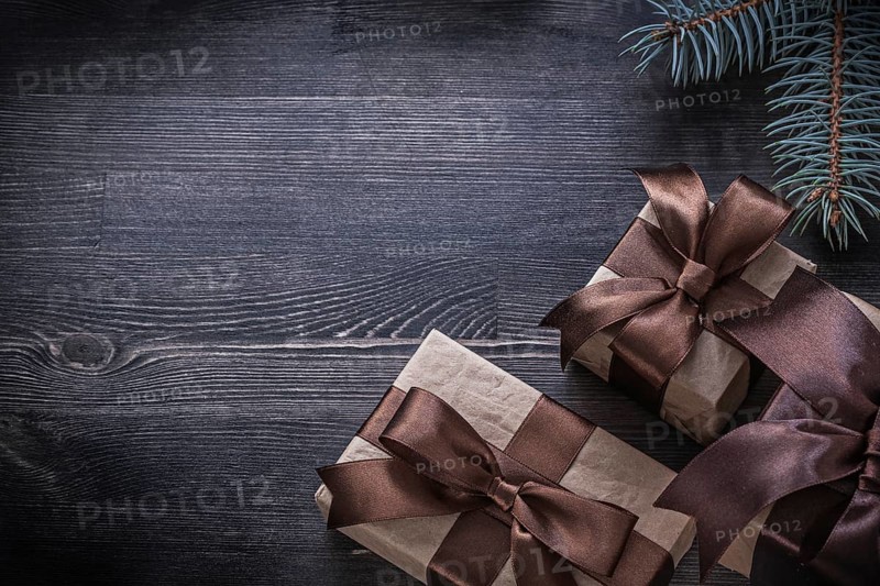 Pine branch packed present box on wooden board holiday concept